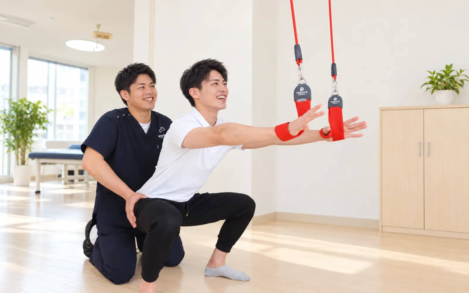 明るい院内で患者様の運動を笑顔で支える柔道整復師
